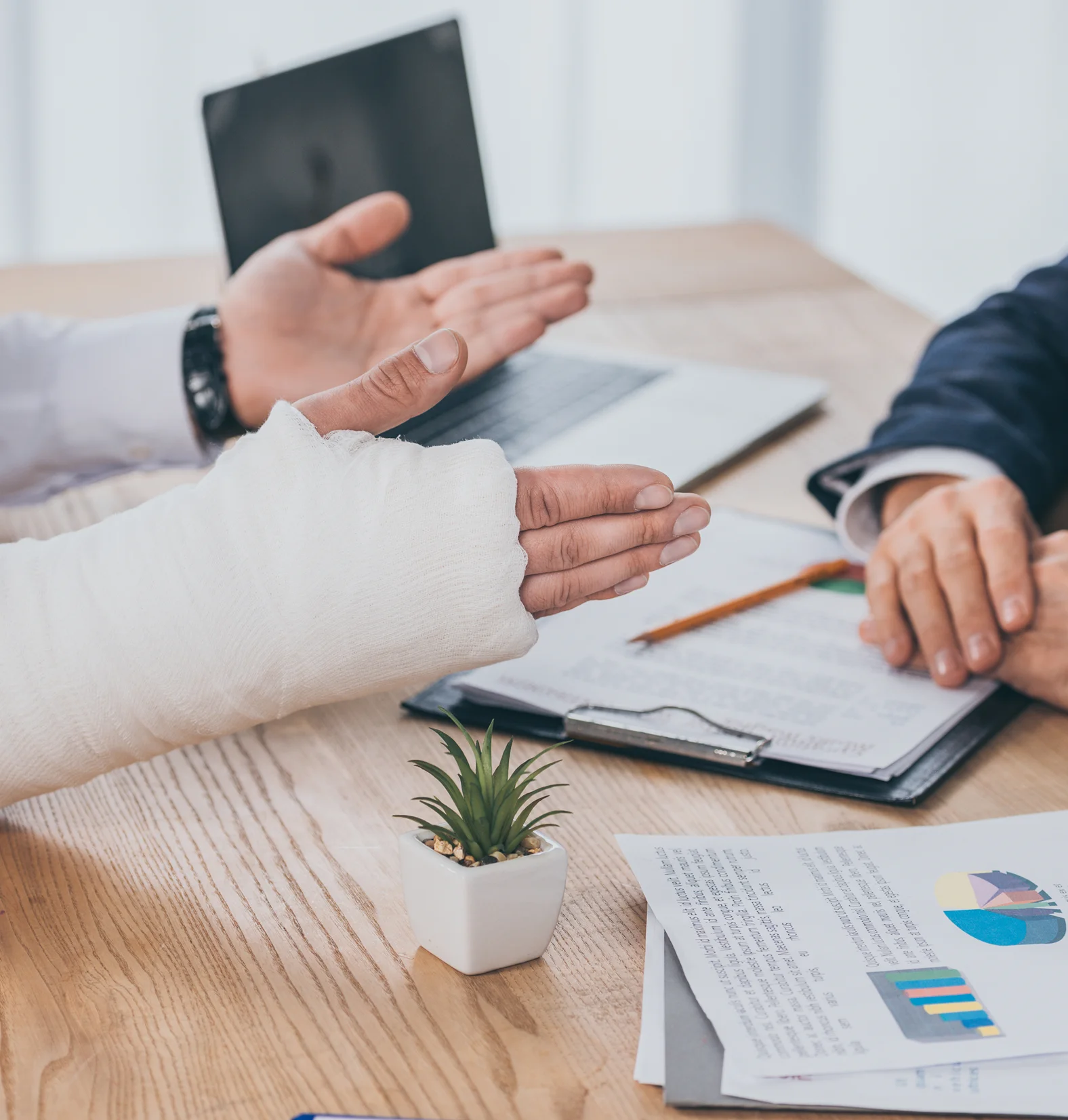 Two professionals discussing documents and data charts at a meeting.